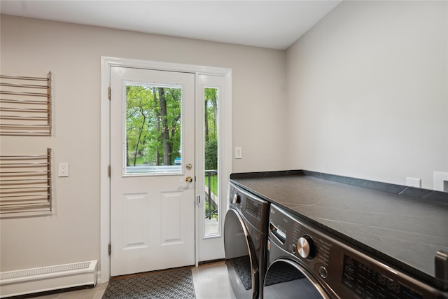 clothes washing area featuring washing machine and clothes dryer, laundry area, light tile patterned floors, and baseboard heating