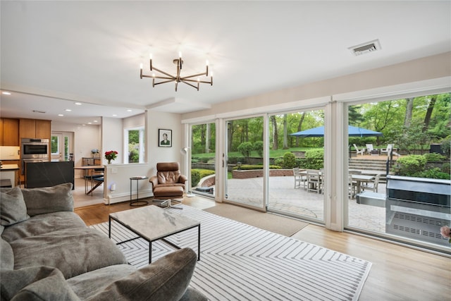 living room featuring a chandelier, light wood finished floors, and recessed lighting