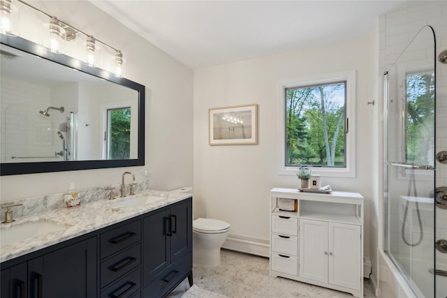 bathroom featuring toilet, plenty of natural light, and a sink