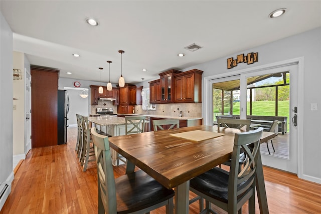 dining room featuring baseboard heating, recessed lighting, baseboards, light wood-type flooring, and visible vents