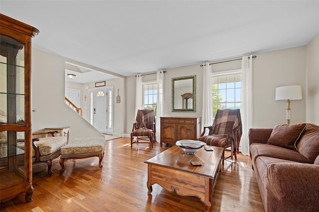 living room featuring stairs, plenty of natural light, and wood finished floors