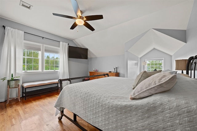 bedroom with visible vents, ceiling fan, wood finished floors, and vaulted ceiling