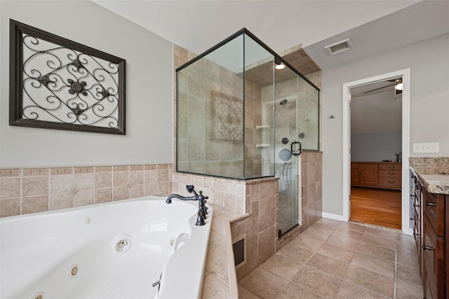 full bathroom featuring visible vents, a jetted tub, vanity, and a shower stall