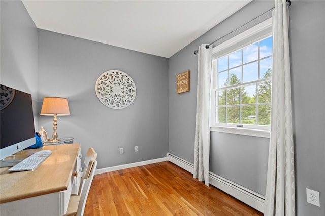 office area with baseboards, baseboard heating, and light wood finished floors