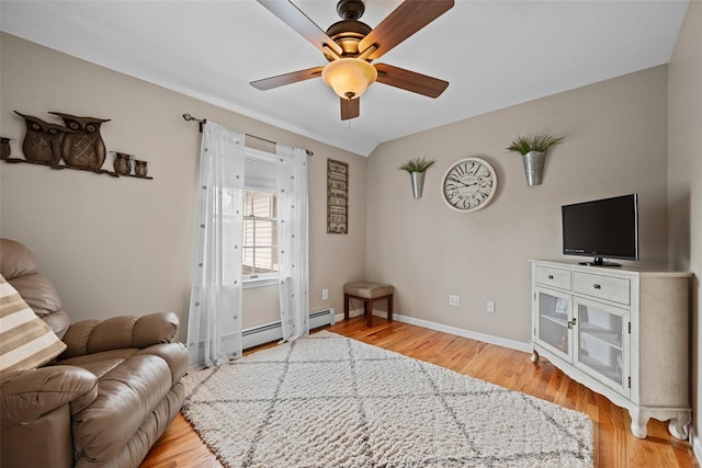 living room featuring a baseboard radiator, baseboards, ceiling fan, and wood finished floors