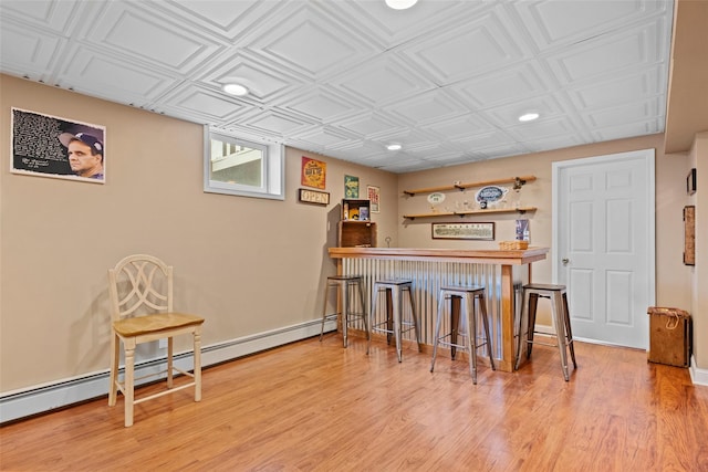 bar featuring a dry bar, baseboard heating, recessed lighting, and wood finished floors