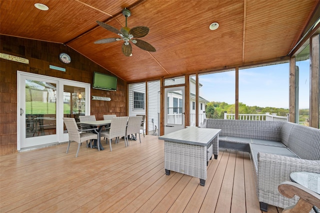 sunroom / solarium featuring outdoor dining space, ceiling fan, and an outdoor living space
