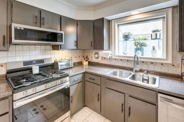 kitchen featuring backsplash, appliances with stainless steel finishes, crown molding, and a sink