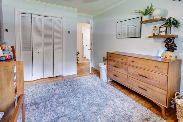 bedroom featuring ornamental molding, a closet, baseboards, and light wood-type flooring