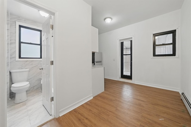4465 Park Ave, Bronx, NY 10457 - interior space with light wood-style flooring, a baseboard heating unit, and baseboards