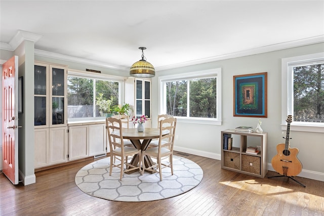 dining space with plenty of natural light, ornamental molding, and baseboards