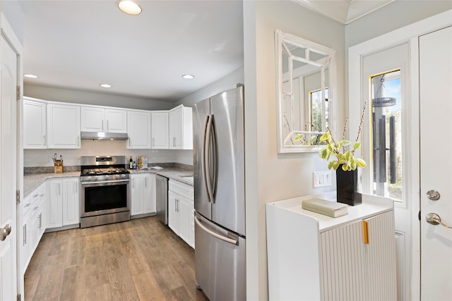 kitchen with white cabinetry, appliances with stainless steel finishes, under cabinet range hood, recessed lighting, and backsplash