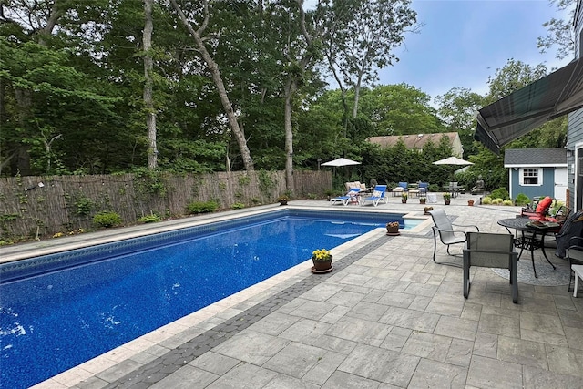 view of swimming pool with a patio, a fenced backyard, an outbuilding, and a fenced in pool