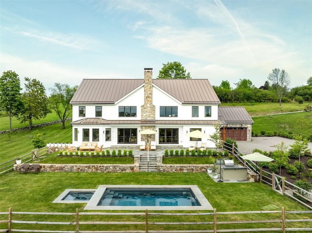 3585 Rte 82, Millbrook, NY 12545 - back of house featuring a chimney, a standing seam roof, an in-ground hot tub, metal roof, and a garage