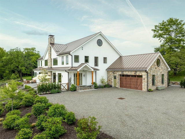 3585 Rte 82, Millbrook, NY 12545 - modern farmhouse style home featuring a standing seam roof, a chimney, metal roof, driveway, and a garage
