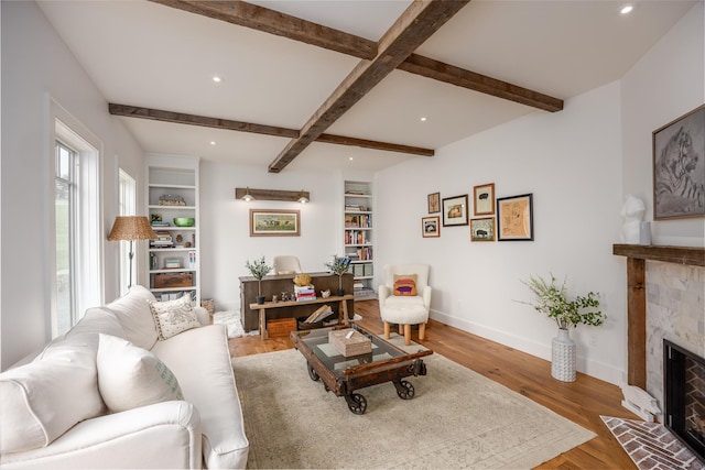 3585 Rte 82, Millbrook, NY 12545 - living area featuring a fireplace with flush hearth, baseboards, beamed ceiling, wood finished floors, and recessed lighting