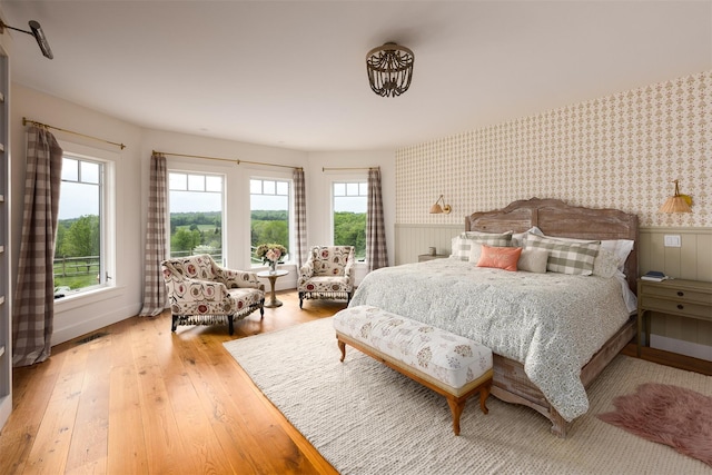 3585 Rte 82, Millbrook, NY 12545 - bedroom with wallpapered walls, wainscoting, and light wood-type flooring