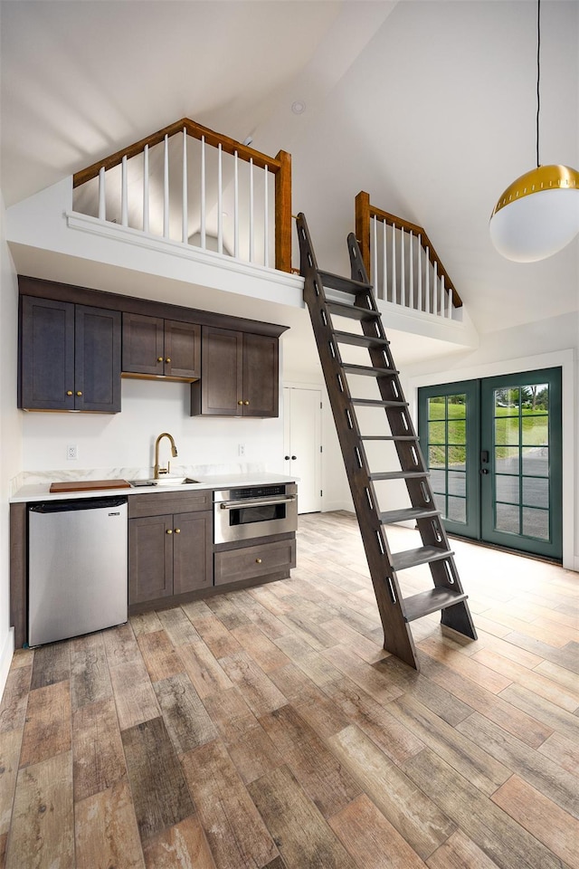 3585 Rte 82, Millbrook, NY 12545 - kitchen featuring dishwasher, high vaulted ceiling, light wood-style floors, a sink, and oven