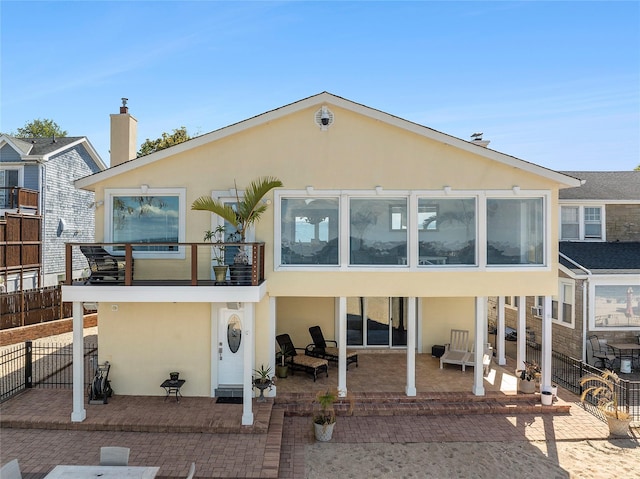 back of house featuring a patio, fence, stucco siding, and a balcony