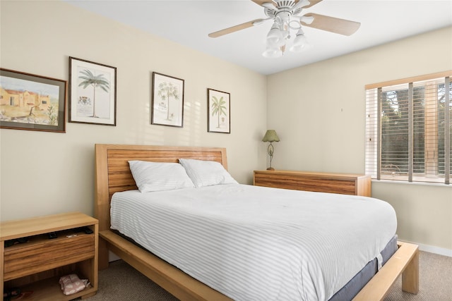 carpeted bedroom with ceiling fan and baseboards