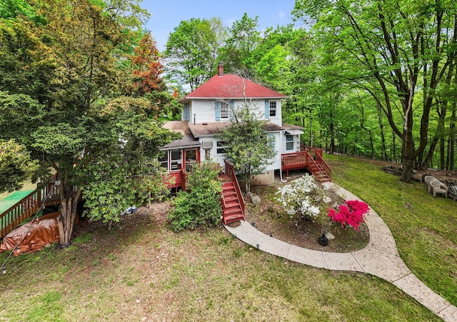 view of grassy yard featuring stairs and a deck