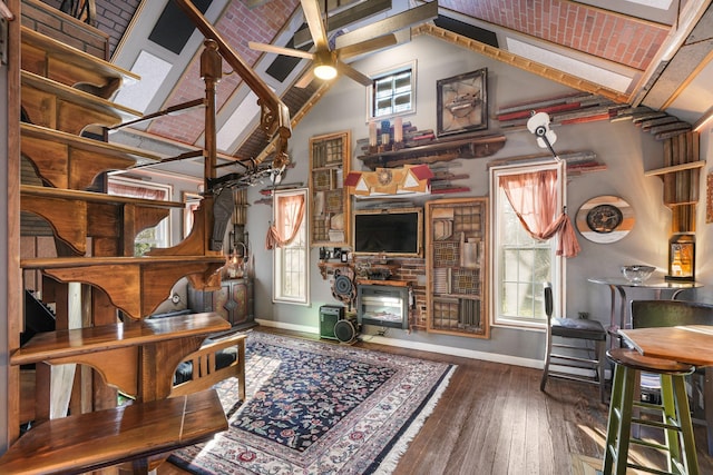 living area featuring baseboards, plenty of natural light, a ceiling fan, and hardwood / wood-style flooring