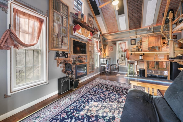living room featuring wood finished floors, baseboards, and a high ceiling