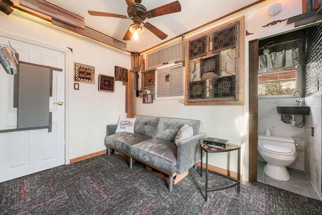 sitting room with a ceiling fan, baseboards, and carpet