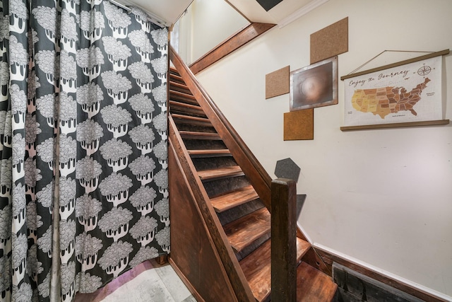 staircase featuring wood finished floors and baseboards