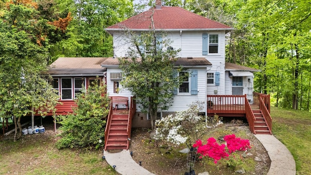 rear view of house with stairs, a deck, and roof with shingles