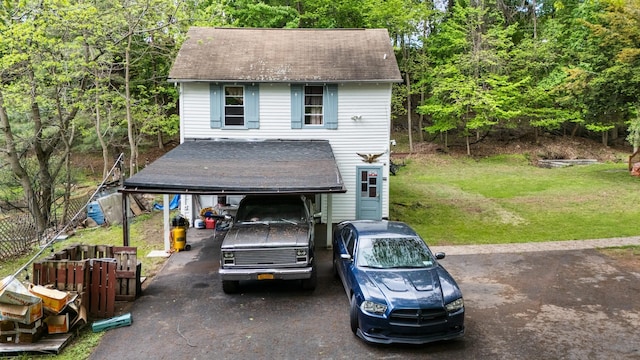 view of front of house featuring a front lawn, asphalt driveway, a shingled roof, and a carport