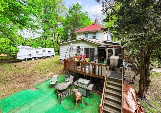 back of house with a deck and a chimney