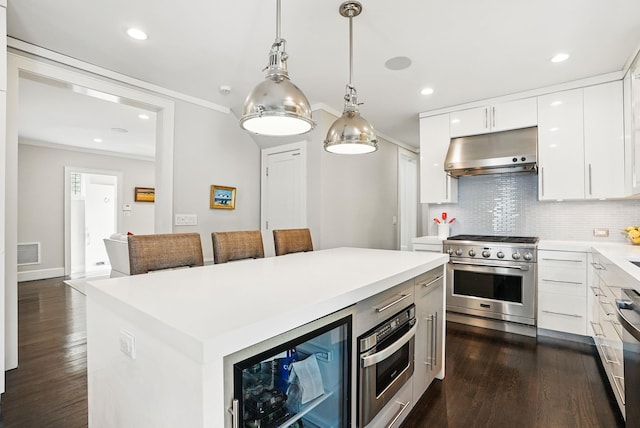 kitchen featuring appliances with stainless steel finishes, under cabinet range hood, dark wood finished floors, and beverage cooler