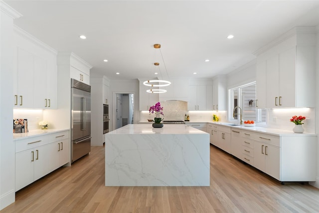 20 Carthage Ln, Scarsdale, NY 10583 - kitchen featuring built in refrigerator, a sink, decorative backsplash, a center island, and white cabinetry