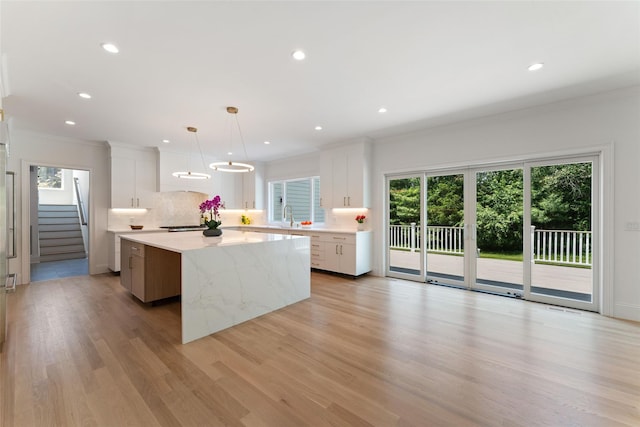20 Carthage Ln, Scarsdale, NY 10583 - kitchen featuring a center island, decorative backsplash, white cabinets, crown molding, and light wood-style floors