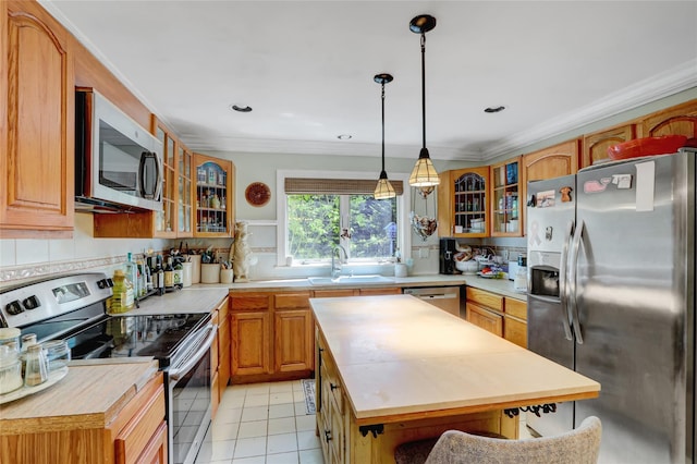 kitchen with appliances with stainless steel finishes, a sink, decorative backsplash, glass insert cabinets, and crown molding