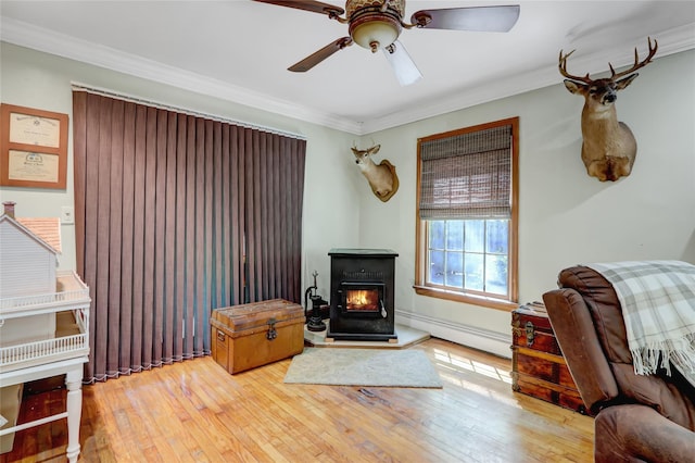living area featuring a baseboard radiator, crown molding, wood-type flooring, and ceiling fan