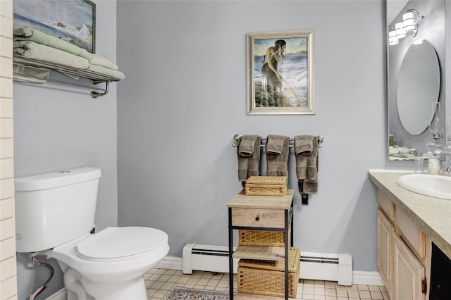 half bathroom with a baseboard radiator, toilet, vanity, tile patterned floors, and baseboards
