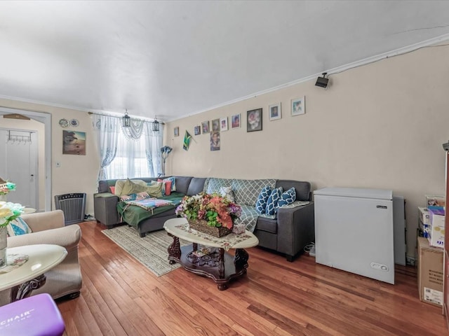 living area featuring wood finished floors and crown molding