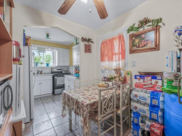 dining area with light tile patterned flooring and a ceiling fan