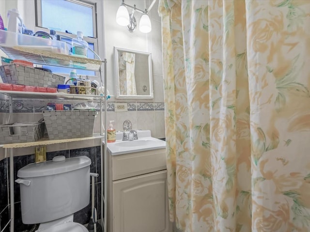 full bathroom featuring toilet, tile walls, and vanity