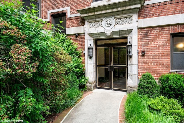view of exterior entry featuring brick siding