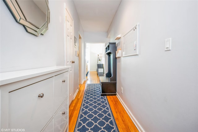 hallway with baseboards and light wood finished floors