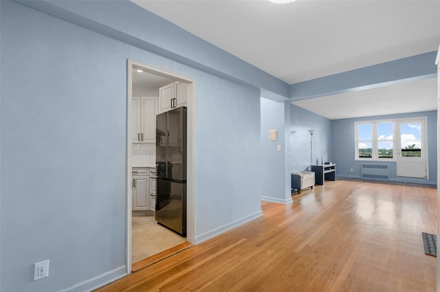 325 King St Unit 4D, Port Chester, NY 10573 - unfurnished living room with radiator and light wood-style floors