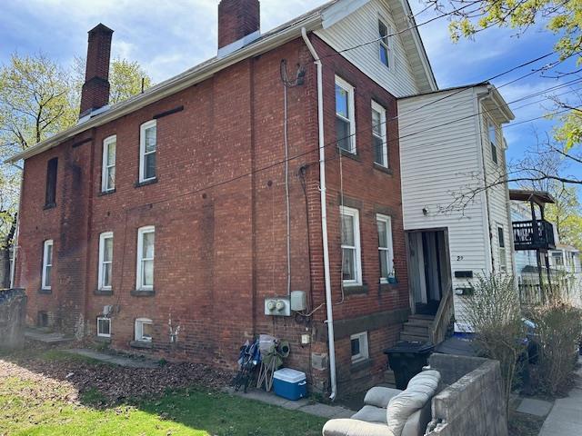 29 Cottage St, Poughkeepsie, NY 12601 - view of side of home with entry steps, a chimney, and brick siding