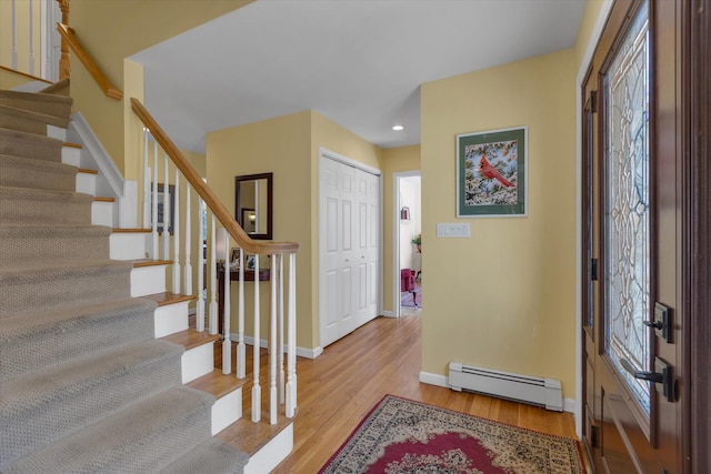 foyer featuring baseboard heating, stairs, baseboards, recessed lighting, and light wood-style flooring