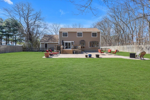 back of property with an outdoor fire pit, a wooden deck, a fenced backyard, a patio area, and a lawn