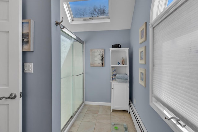 bathroom featuring a baseboard radiator, tile patterned floors, a skylight, and a shower stall
