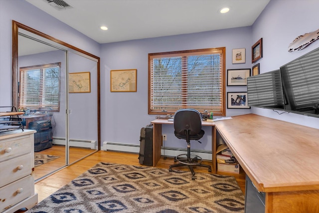 office space with visible vents, light wood-style flooring, and a baseboard radiator