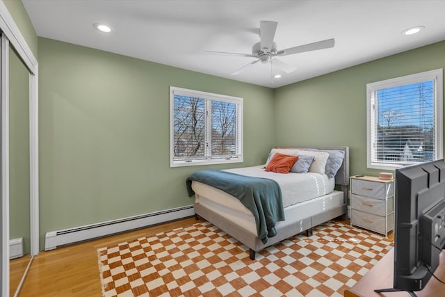 bedroom featuring a ceiling fan, light wood-style floors, recessed lighting, and a baseboard radiator